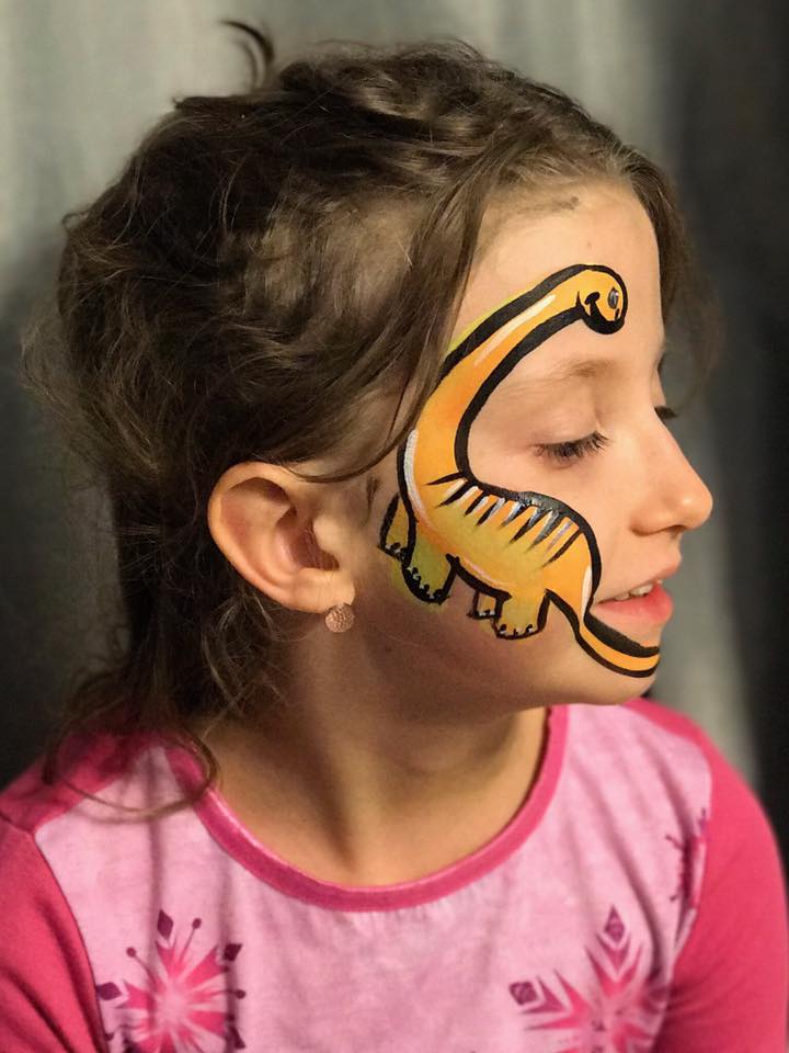 Child with exciting dinosaur face painting design